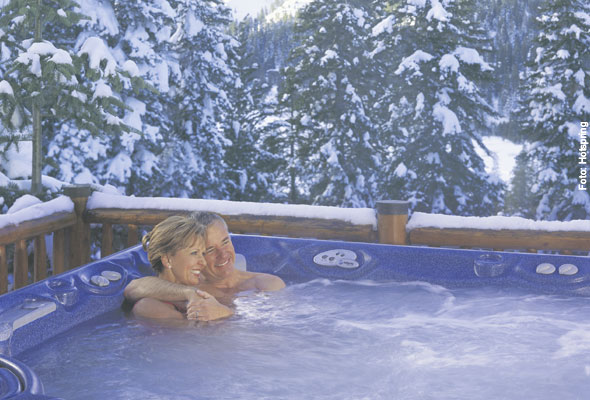 Whirlpool mit badenden Personen im Freien im Winter 